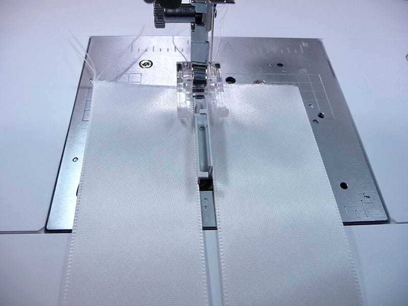 A picture containing machine, sewing machine, tool, sewing